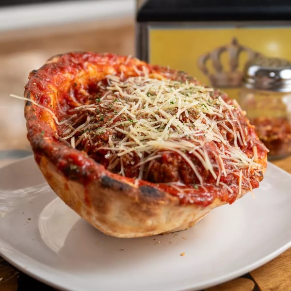 Deep dish pizza from Royal Pizza, topped with rich red sauce, meatballs, and shredded cheese.